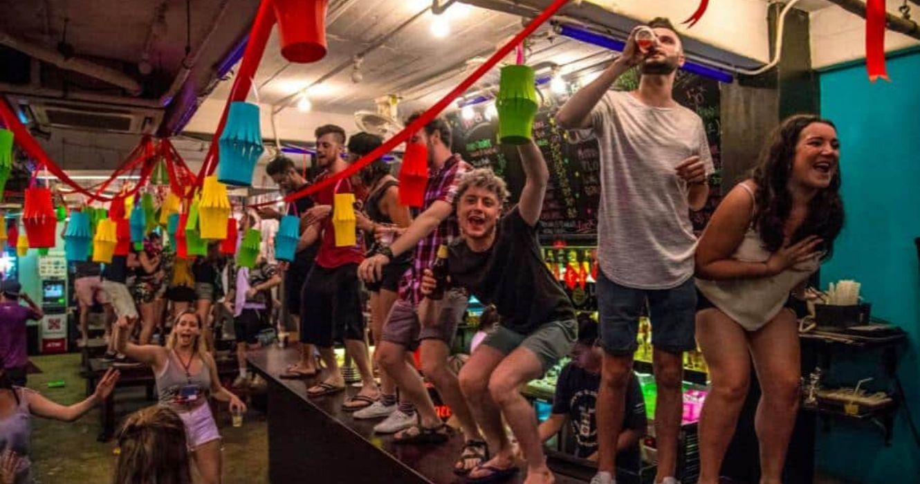 mochileiros se divertindo no bar do albergue no sudeste da Ásia