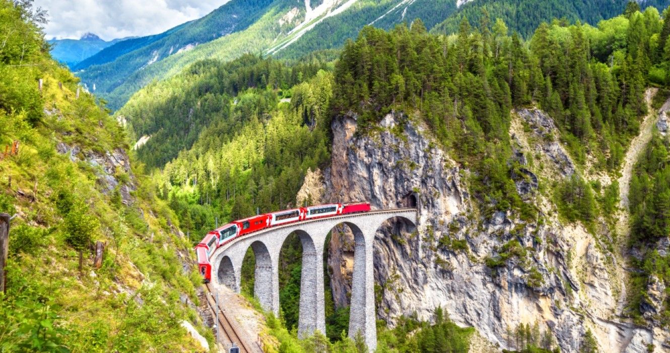 Trem de Bernina Express na ponte ferroviária nas montanhas em Landwasser Viaduct, Filisur, Suíça