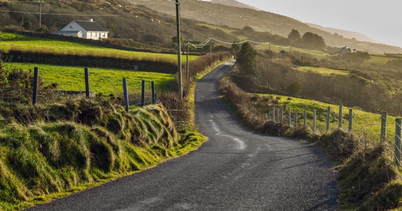 uma estrada através de fazendas na Irlanda
